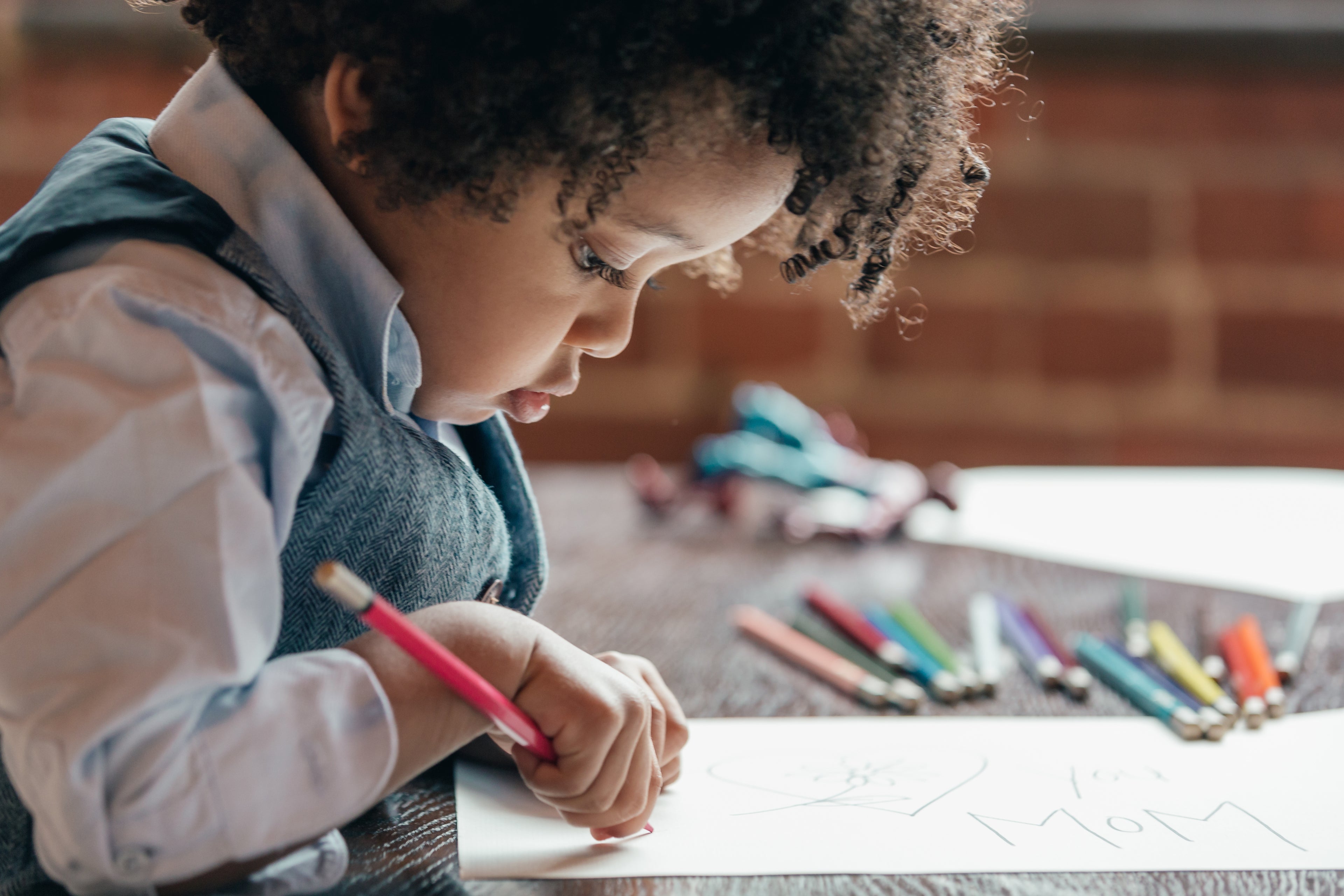 Young boy drawing with coloured pencils