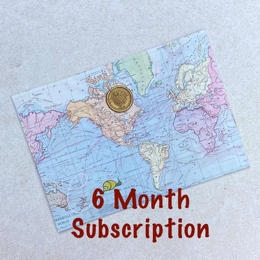 One envelope printed with map design and a gold seal above a heading saying '6 month subscription'