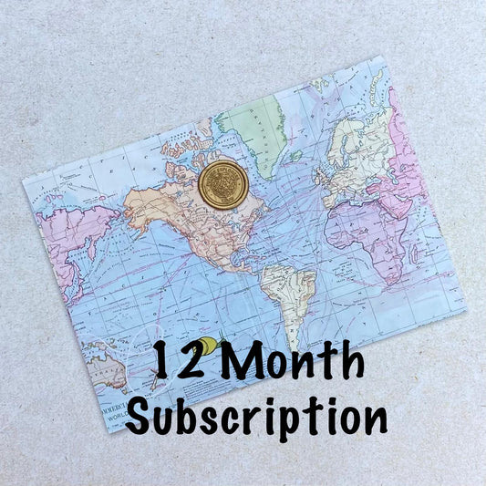 One envelope printed with map design and a gold seal above a heading saying '12 month subscription'