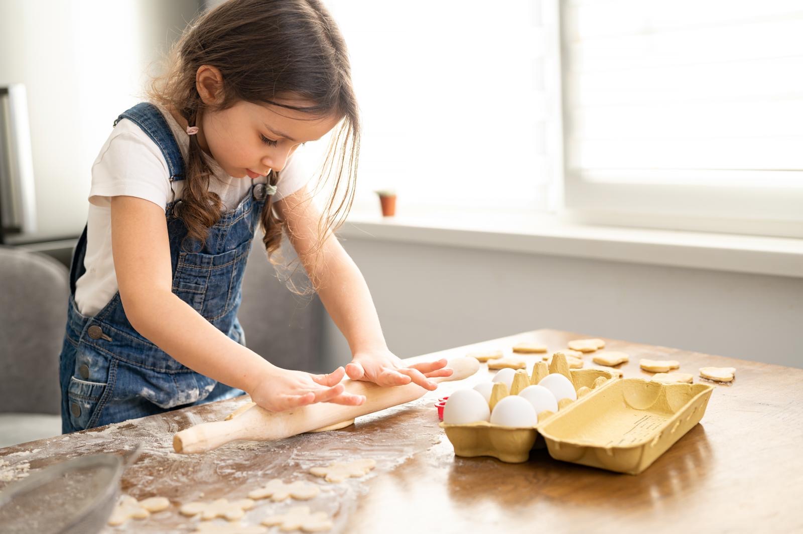 Young girl rolling out pastry 