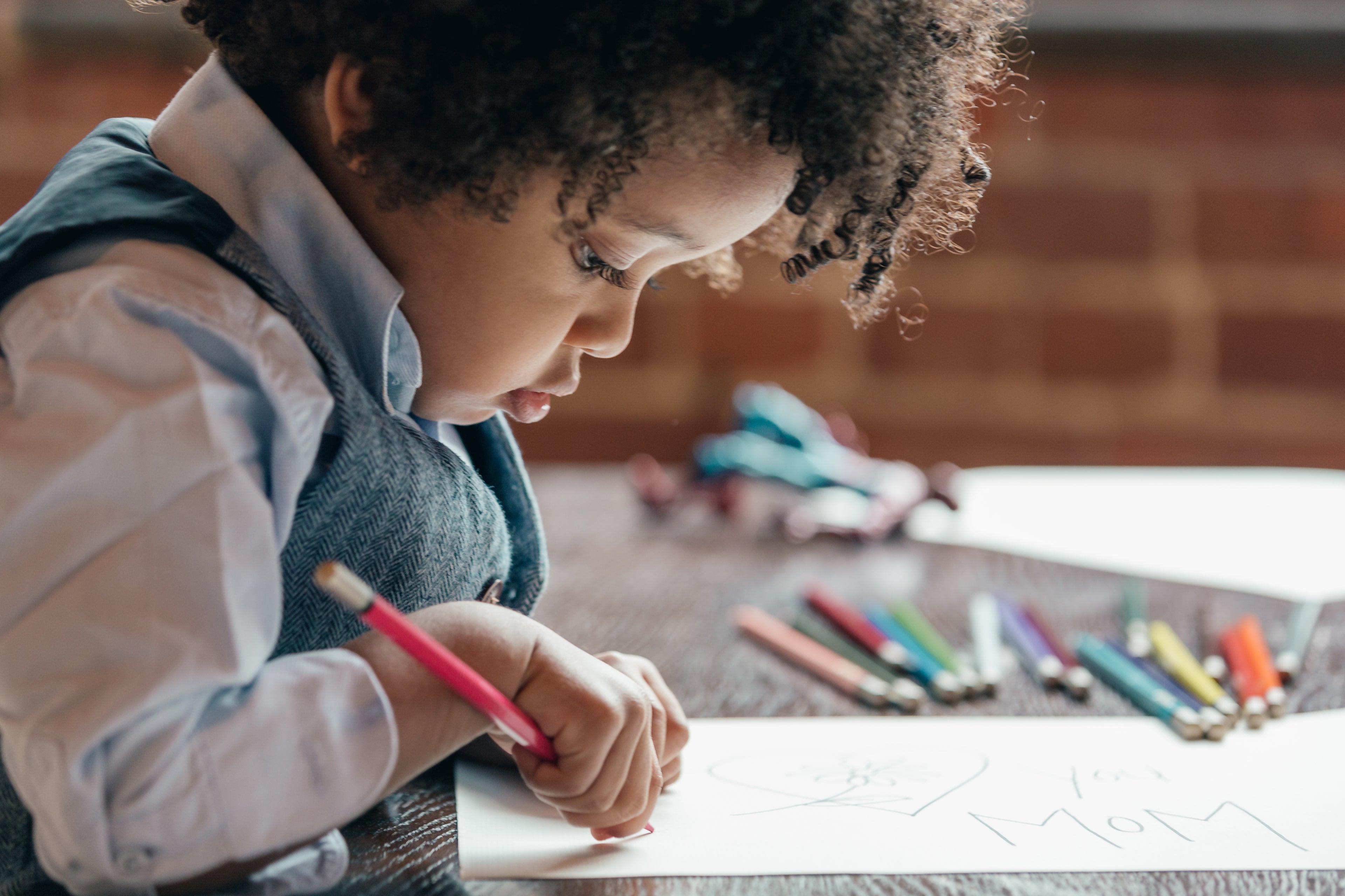 Young boy drawing with coloured pencils 